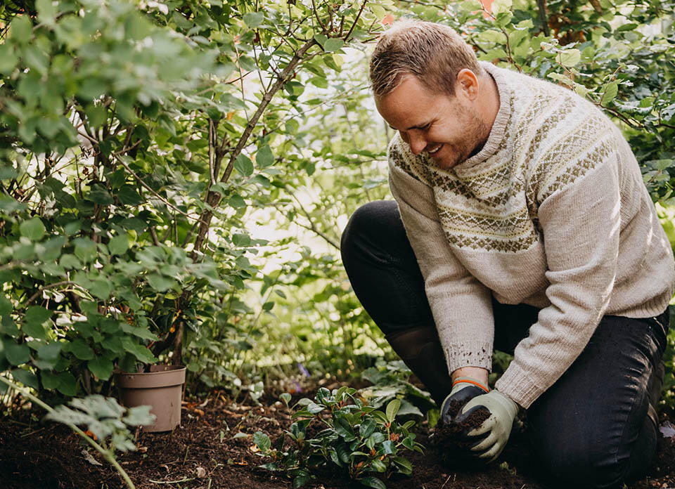 En man som planterar en planta.